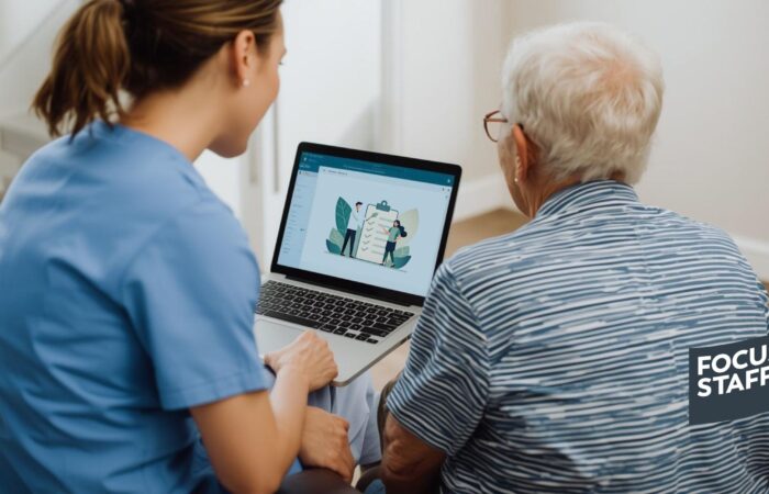 An occupational therapist and an elderly patient sitting together, successfully navigating a telehealth portal on a laptop